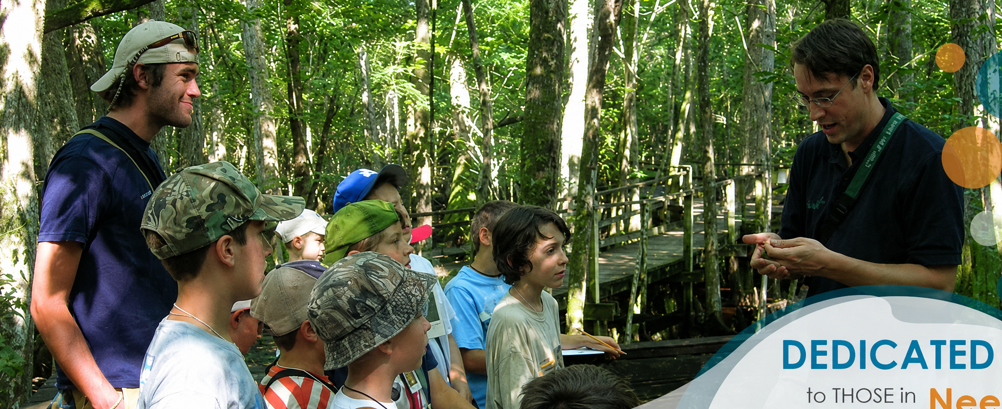 Children and instructors on an outdoor walk through wooded terrain